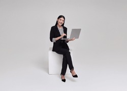 Young Businesswoman Asian Happy Smiling. While Her Using Laptop Sitting On White Chair Isolated On Copy Space White Studio Background.
