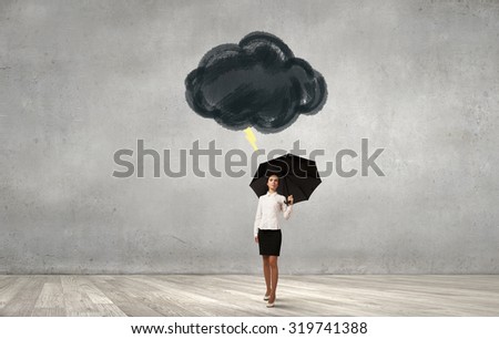 Young businesswoman with black umbrella standing under black cloud