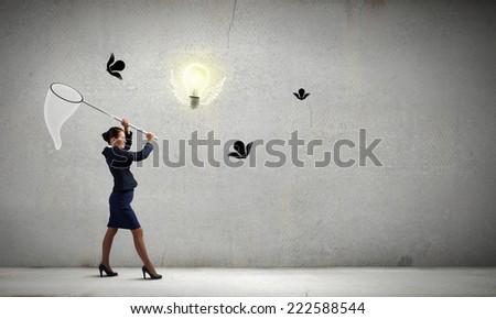 Young businesswoman catching light bulb with hoop