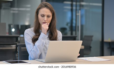 Young Businesswoman Coughing While Using Laptop At Work