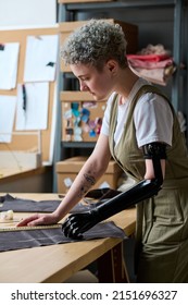 Young Businesswoman With Disability Looking At Piece Of Textile At Work