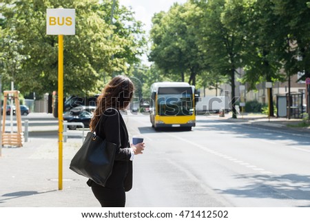 Young Businesswoman With Disposal Cup Waiting For Bus