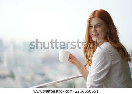 Young businesswoman drinking coffee in her office. Woman enjoy in coffee break.