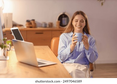 Young businesswoman drinking coffee in office at night - Powered by Shutterstock