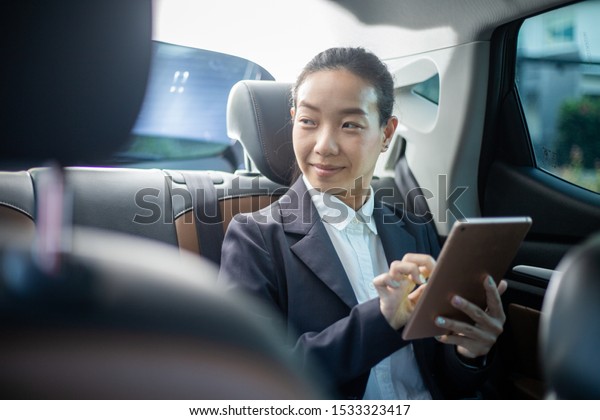 Young businesswoman with driver in luxury car.\
Chauffeur service