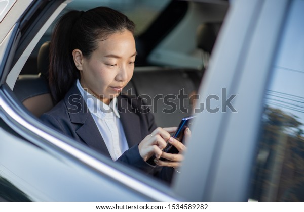 Young businesswoman with driver in luxury car.\
Chauffeur service