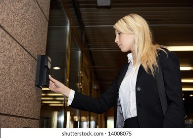 Young Businesswoman Entering Access Code At Building Entrance