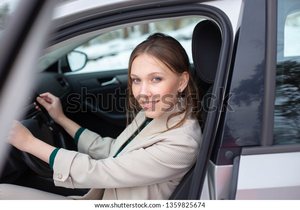 A young\
businesswoman is exiting a\
car