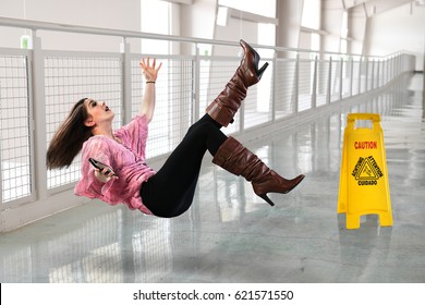 Young businesswoman falling on floor inside office building
