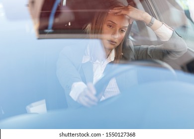 Young Businesswoman Feeling Annoyed While Driving A Car And Being Stuck In A Traffic Jam. The View Is Through The Glass. 