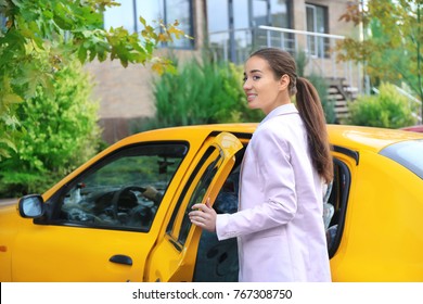 Young Businesswoman Getting Into Taxi Car