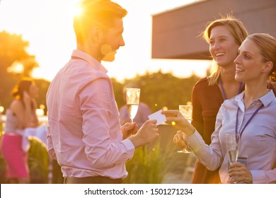 Young Businesswoman Giving Business Card To Colleague While Holding Wine Glass On Success Party At Rooftop