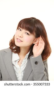 Young Businesswoman With Hand Behind Ear Listening Closely