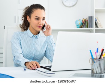 young businesswoman having negotiations by phone in office