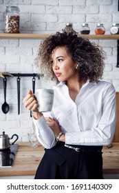 A Young Businesswoman Holding A Coffee Cup And Looking Away