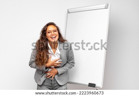 young businesswoman laughing out loud at some hilarious joke, feeling happy and cheerful, having fun