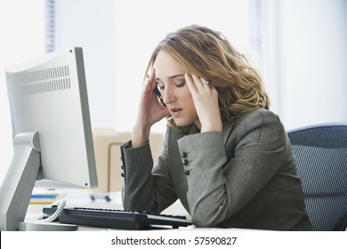 A young businesswoman is looking stressed as she works at her computer. Horizontal shot. - Powered by Shutterstock