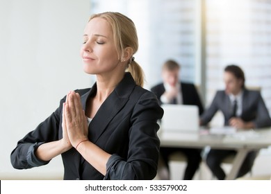 Young businesswoman meditating, habits of successful woman, taking care of herself in personal and business life, staying present and cherishing all the good life. Relaxation techniques at workplace