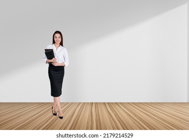 Young Businesswoman With Notebook In Hands, Looking At Camera On White Copy Space Background, Hardwood Floor. Concept Of Alumni And Career.