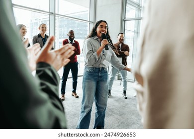 Young businesswoman presenting to a group of colleagues in a modern office. Motivational leader engaging team with a successful presentation. - Powered by Shutterstock