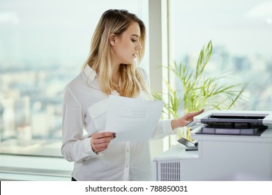 young businesswoman prints on the printer in the office