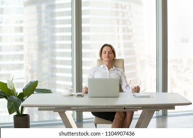 Young Businesswoman Relaxing Leaning On Comfortable Ergonomic Chair In Modern Office Room, Calm Happy Employee Feels No Stress Free Relief Taking Break To Rest From Computer Work Breathing Fresh Air