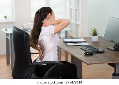 Young Businesswoman Sitting On Chair Having Backpain In Office