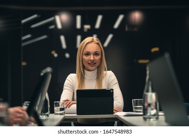 Die junge Geschäftsfrau, die auf der Wirtschaftskonferenz am Tisch sitzt