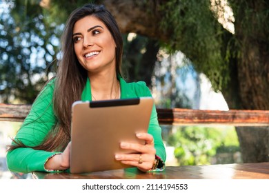 Young Businesswoman Sitting And Using Tablet To Work In Table Outside