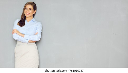 Young businesswoman standing against gray wall with copy space for signs. Isolated portrait.
