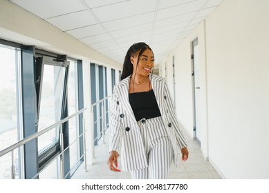 Young Businesswoman Standing In Corridor Of Modern Office Building