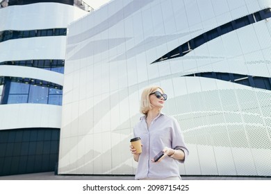 A young businesswoman standing looking at the infirmation on smart phone - Shutterstock ID 2098715425