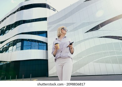 A young businesswoman standing looking at the infirmation on smart phone - Shutterstock ID 2098836817