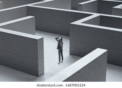 Young businesswoman standing in middle of a gray concrete labyrinth. Business and challenge concept. - Shutterstock ID 1687001224