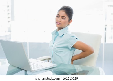 Young Businesswoman Suffering From Back Ache In Front Of Laptop In The Office