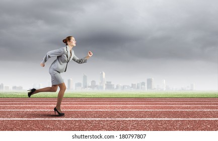 Young businesswoman in suit running on track - Powered by Shutterstock