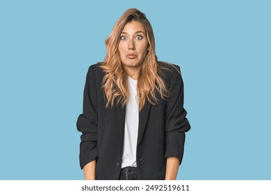 Young businesswoman in a suit shrugs shoulders and open eyes confused. - Powered by Shutterstock