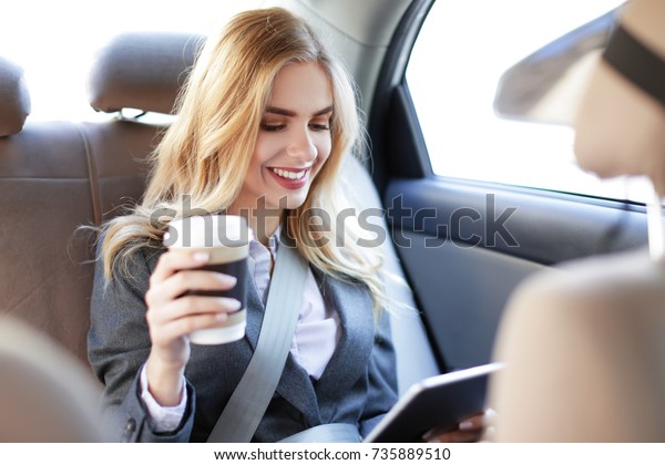 Young businesswoman with\
tablet in car