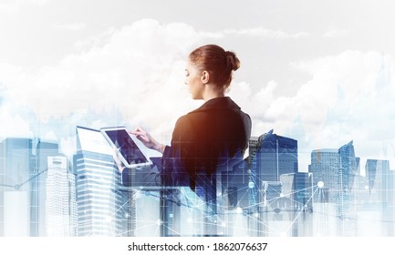 Young businesswoman with tablet computer on modern cityscape background. Double exposure concept with beautiful woman in business suit. Digital technology in stock trading and real estate investment - Shutterstock ID 1862076637