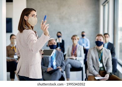 Young Businesswoman Talking While Holding Presentation To Group Of Coworkers On Education Event During Coronavirus Pandemic.