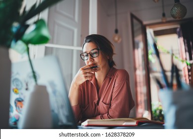 Young businesswoman thinking about something while sitting front open portable laptop computer reading email from client, long hours of work concept - Shutterstock ID 1628378209