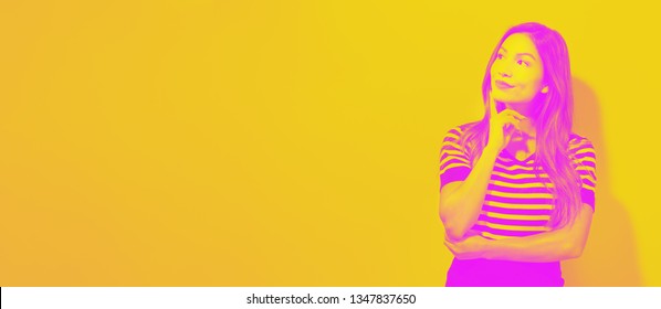 Young Businesswoman In A Thoughtful Face In A Pink And Yellow Duotone