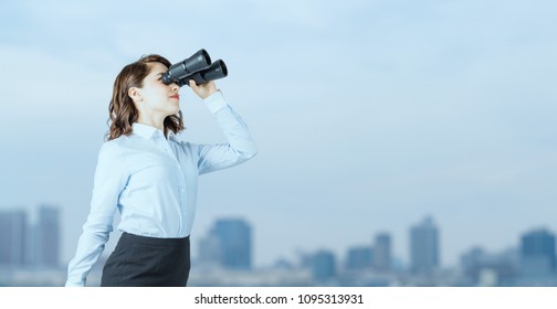 Young businesswoman using binoculars in front of the city. - Powered by Shutterstock