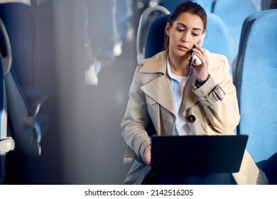 Young businesswoman using laptop and talking on the phone while commuting to work by train.