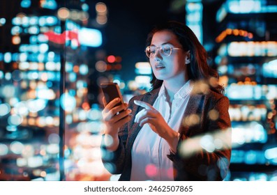 Young businesswoman using phone near window in the evening. - Powered by Shutterstock