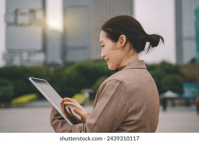 Young Businesswoman Using Tablet in Urban Setting - Powered by Shutterstock