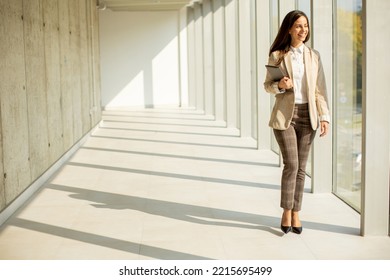 Young Businesswoman Walking On Modern Office Hallway On A Sunny Day