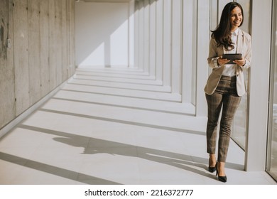 Young Businesswoman Walking On Modern Office Hallway On A Sunny Day