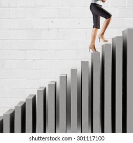 Young businesswoman walking up on staircase representing success concept