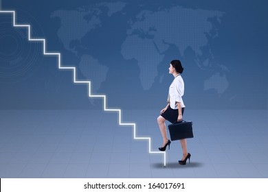 Young businesswoman walking up on stairs with world map background - Powered by Shutterstock